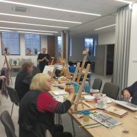 3 seniorow w trakcie malowania obrazu na sztaludze  8 luty 2022  