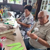 florystyka   dwoch seniorow robi kwiaty  