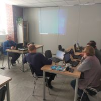 seniorzy w trakcie kursu kompterowego nauka na lapotopach z prowadzacym  7 marzec